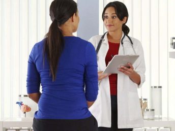 Mexican,Doctor,Talking,To,African,American,Patient,Using,Pad